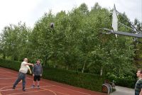 Mieszkańcy grają w piłkę koszykową na boisku w Ogrodzie.