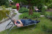 Mieszkańcy podczas odpoczynku na leżakach w ogrodzie.