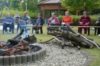 Mieszkańcy podczas spotkania przy ognisku w Ogrodzie Terapeutycznym.