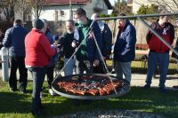 Terapeuci podają Mieszkańcom grillowane kiełbaski i kaszankę.