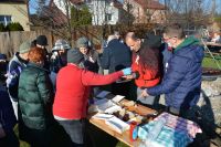 Terapeuci podają uczestnikom spotkania grillowane kiełbaski i kaszankę.