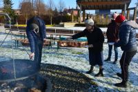 Terapeuci podają Mieszkańcom pieczone kiełbaski.