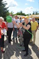 Pani Magda wykonuje rzut kostką w konkursie z nagrodami.