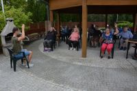Gimnastyka poranna w cieniu altany w Ogrodzie Terapeutycznym.