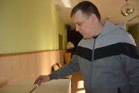 Pan Dominik wrzuca formularz do urny wyborczej.
