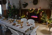 Wigilijne stoły w pobliżu kominka i bożonarodzeniowej choinki.