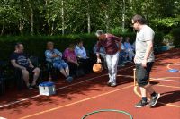 Pani Ewa dzielnie pokonuje tor przeszkód podczas zajęć sportowych na boisku.
