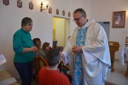 Mieszkańcy przyjmują Komunię Świętą podczas nabożeństwa w kaplicy Domu.