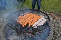 Na ruszcie zawieszonym nad ogniskiem pieką się już kiełbaski i kaszanka.